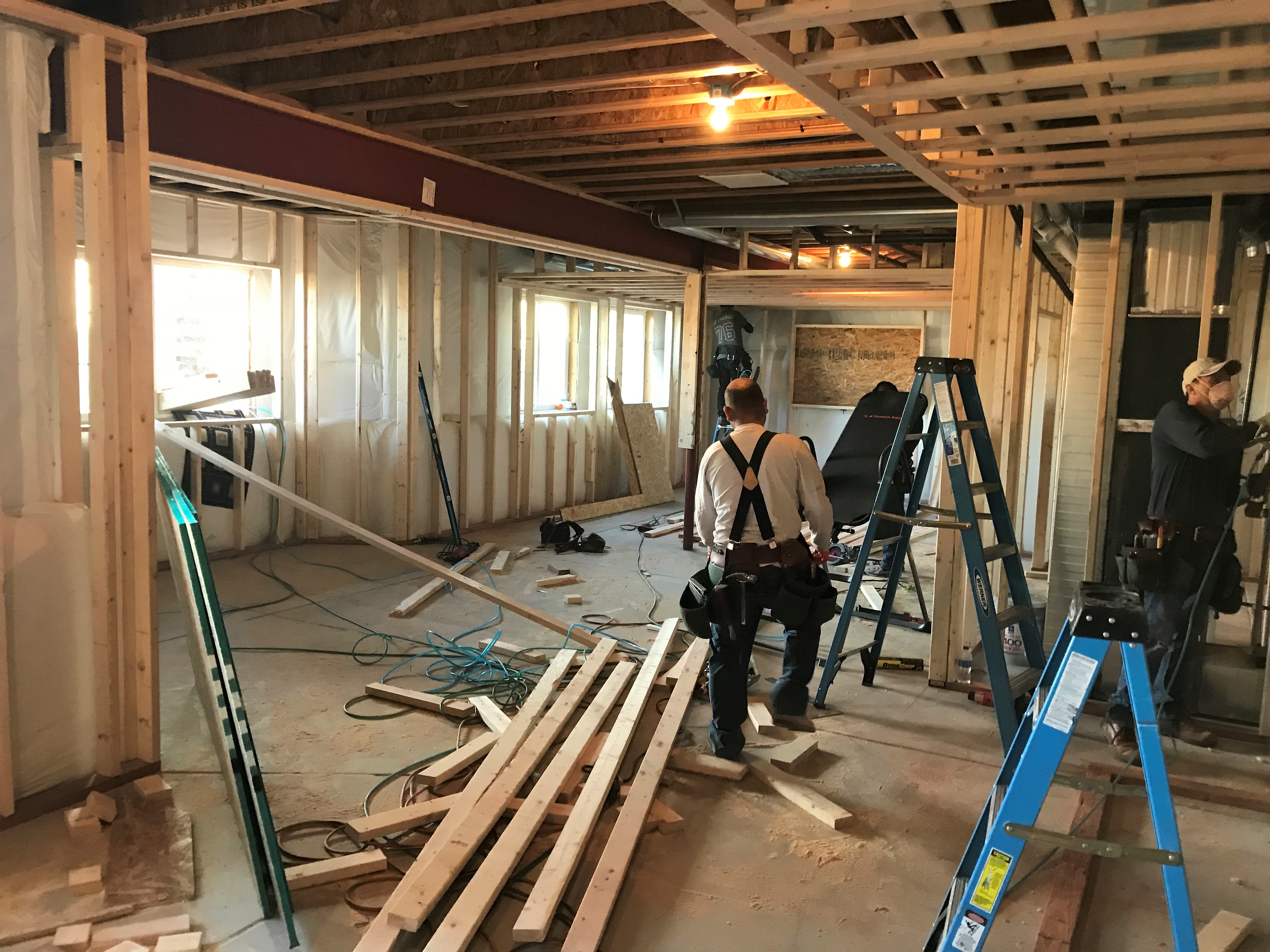 people installing the rough framing of a basement build