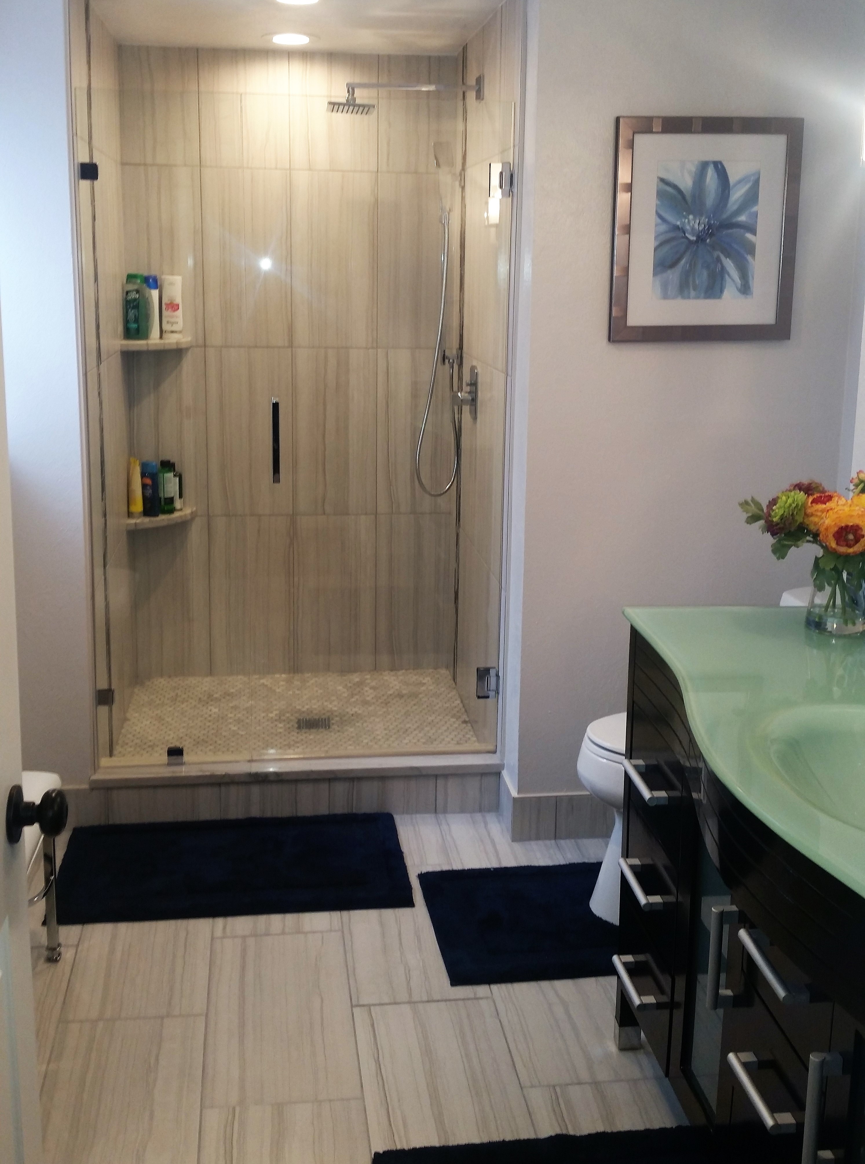 green countertop and black cabinet bathroom vanity with a shower